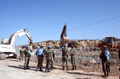 جرافتان دولية واسرائيلية تعملان على جانبي السياج الحدودي أمس
