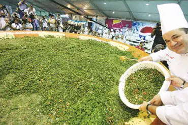 الشيف رمزي أثناء مشاركته في تحضير أكبر طبق تبولة في العالم (أ.ب)