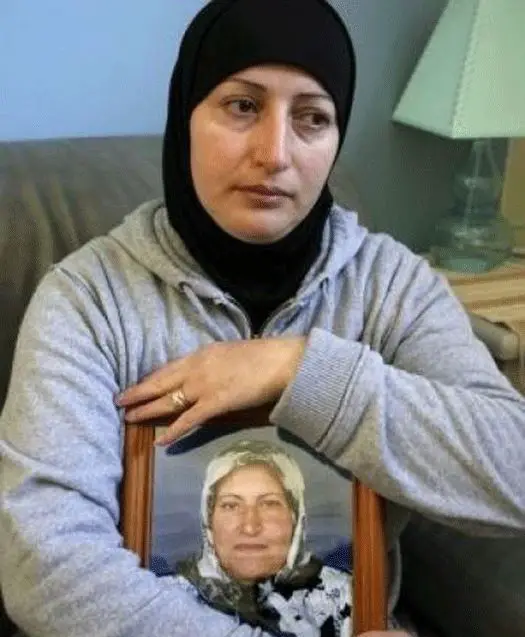 سلوى حيدر (45 عاما) التي قتلت على يد زوجها حيدر حيدر تحمل صورة والدتها التي قضت في تفجير في جنوب لبنان