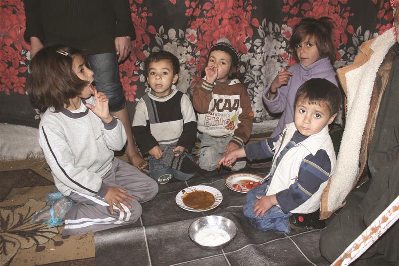 مجموعة من الأطفال حول صحن عشاء (طارق أبو حمدان)