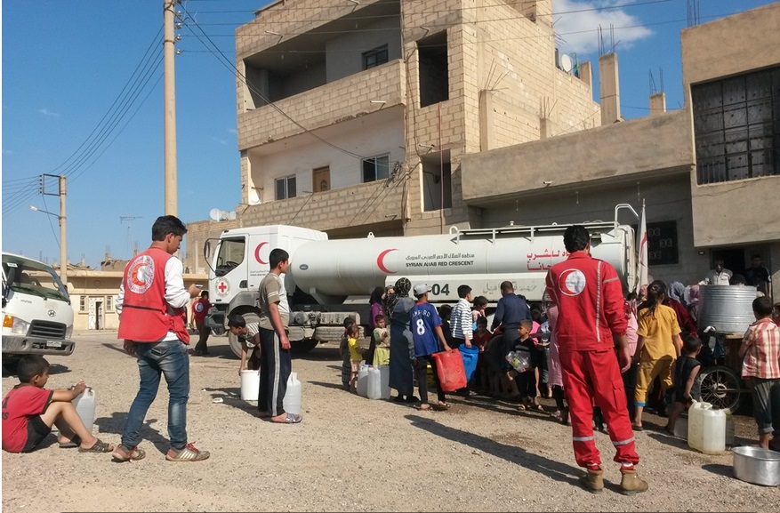 أثناء توزيع الهلال الأحمر السوري المياه لسكان دمشق (أ ف ب)
