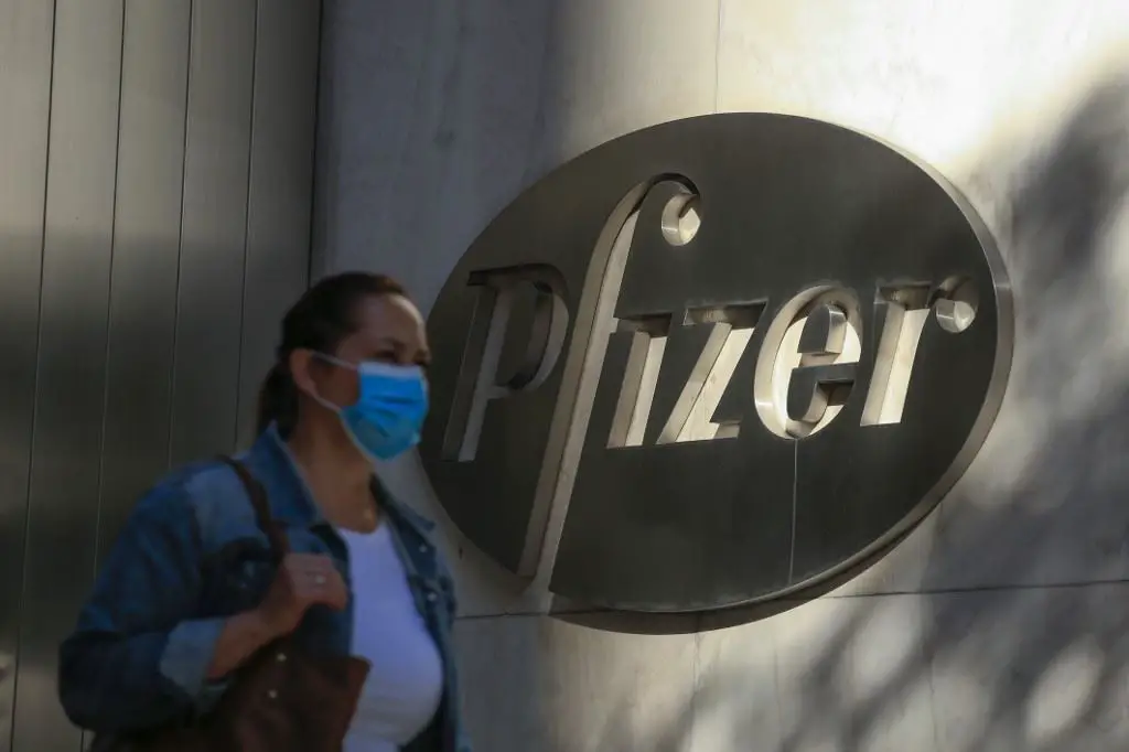 امرأة تمر قبالة مقر شركة بفايزر للقاحات في نيويورك أمس.(أ ف ب)