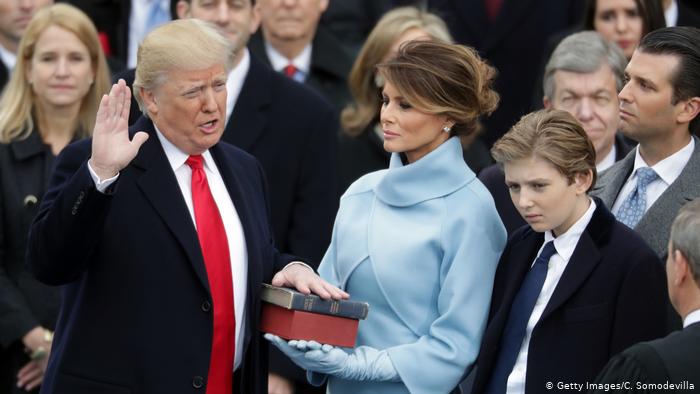 يوم التنصيب: ميلانيا بثوب أزرق تمسك بالكتاب المقدس وهو يقسم عليه لخدمة الولايات المتحدة الأميركية كرئيس لجميع الأميركيين