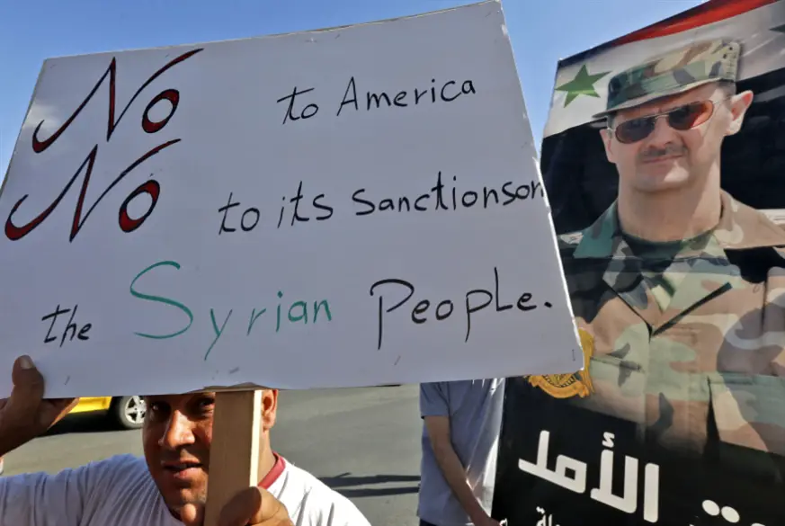 شهدت دمشق تظاهرة رفعت أعلاماً وصوراً للرئيس السوري وهاجمت العقوبات الأميركية (أ ف ب )