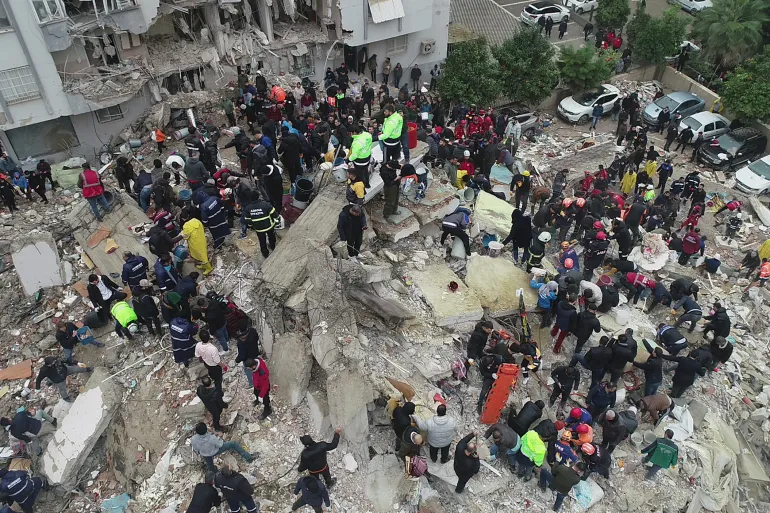 فرق الإنقاذ تبحث عن ناجين بين أنقاض مباني دمرها الزلزال في أضنة التركية (رويترز)