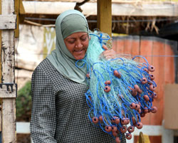 تحمل يومياً الشباك على كتفها