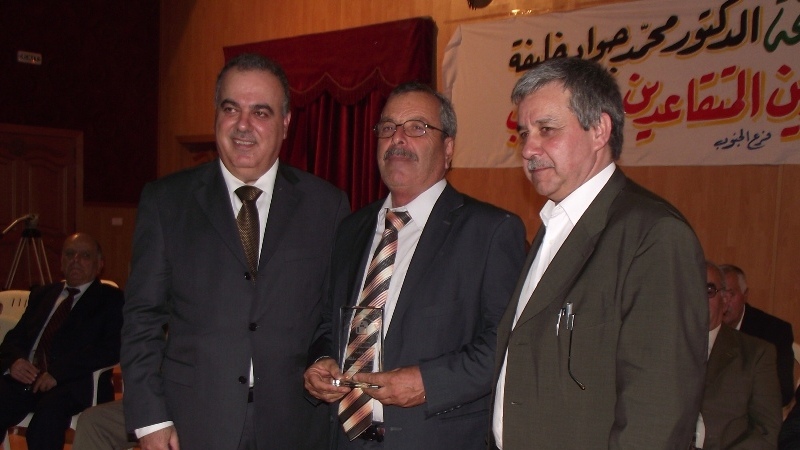 خلفية يسلم أحد المكرمين درعا تقديريا