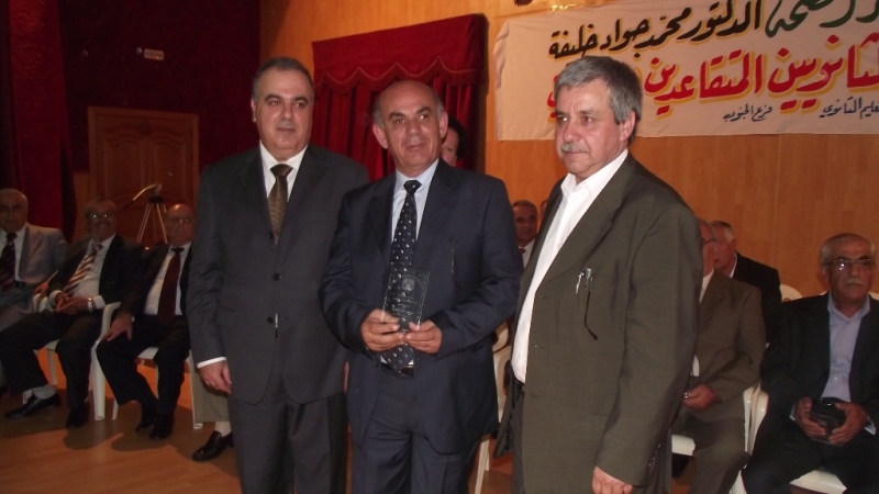 خلفية يسلم أحد المكرمين درعا تقديريا آخر