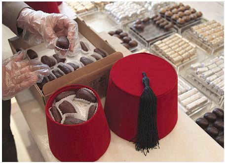 عامل يضع حبات التمر في وعاء على شكل طربوش كهدية خاصة خلال شهر رمضان في أحد محلات دمشق