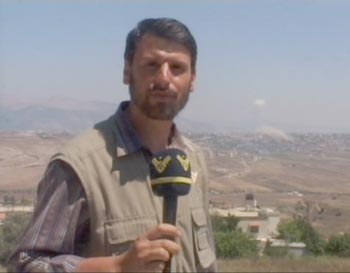 علي شعيب خلال عدوان تموز وتظهر بلدة الخيام خلفه