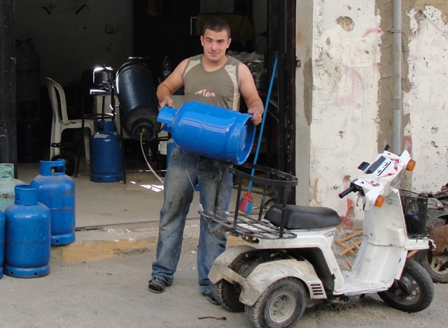 علاء شحرور يعمل على تعبئة وبيع وتوزيع الغاز