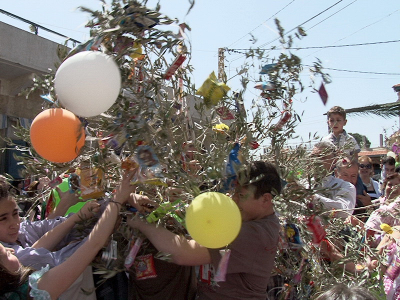 DSC06405 FOTO GEORGE ACHY -- الاطفال يقطفون الحلوى على انواعها من شجرة الزيتون رمز السلام