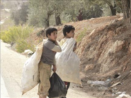 طفلان نازحان يجمعان ما تيسر للتدفئة (طارق أبو حمدان)