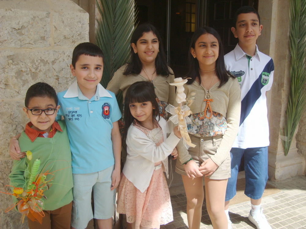 اطفال الشعانين بثيابهم الزاهية وشموعهم الملونة.