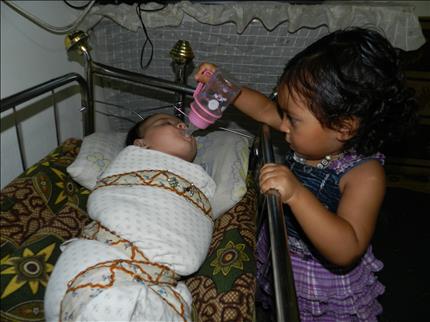  طفلة تطعم شقيقها في مدرسة مرج الزهور («السفير»)