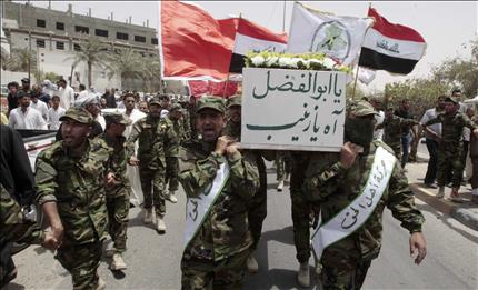 عراقيون يشاركون في جنازة مقاتل عراقي قتل خلال المعارك ضد المعارضة السورية المسلحة في القصير يوم الاثنين الماضي في البصرة أمس (رويترز)