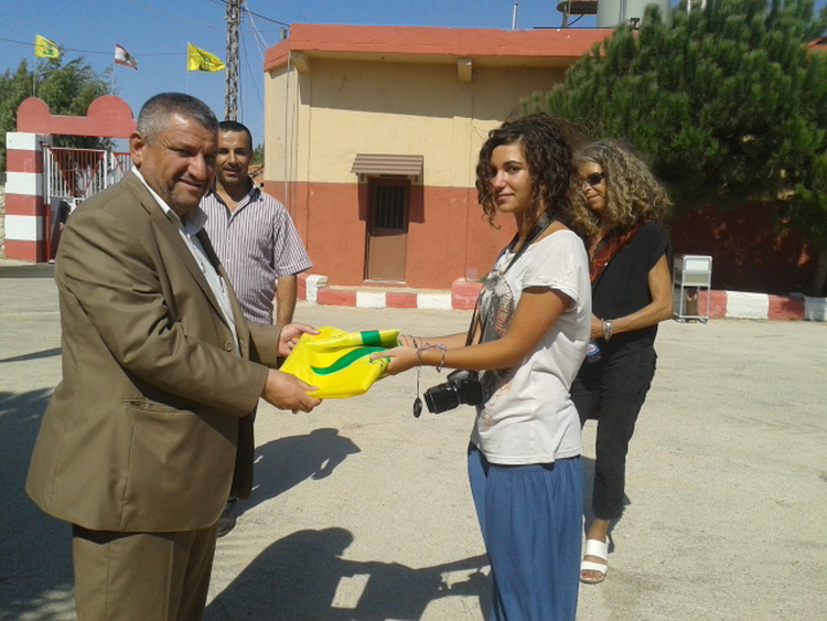 الشيخ علوية يقدم راية حزب الله الى الناشطة الايطالية ستيلا