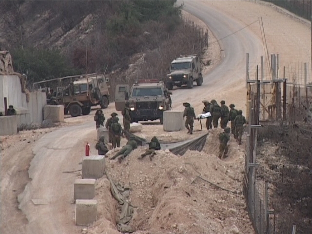 جنود العدو ينقلون جريحا أصيب بالانفجار