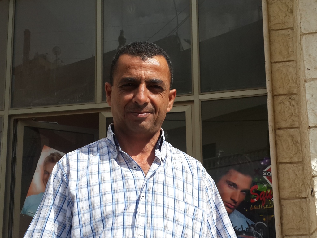 علي الضابط، الحلاق الرجالي المتمرس في عمله، نراه مزهواً هذه الأيام وسعيداً بما فعل  بعدما نقل صالونه إلى مبنى آخر