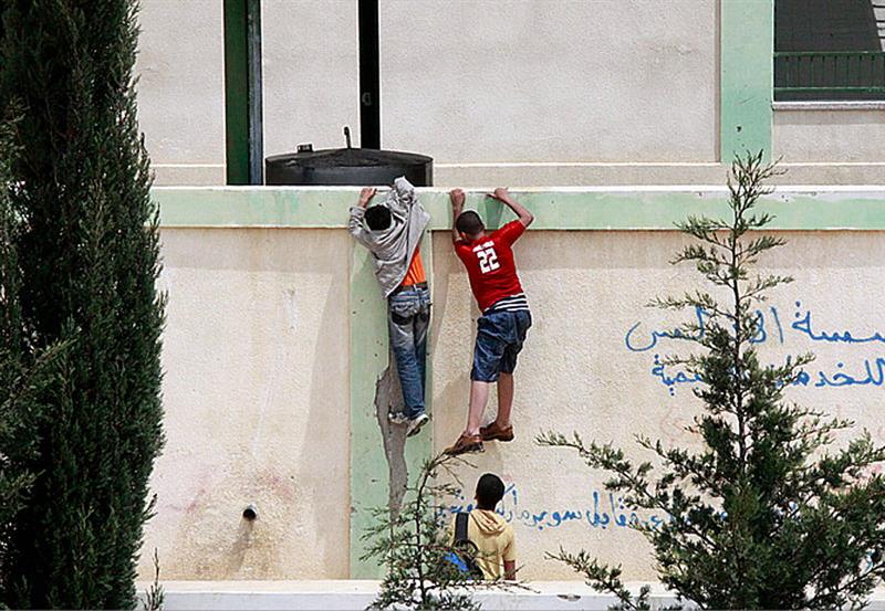 تلامذة على سور إحدى المدارس الرسمية في النبطية (عدنان طباجة)