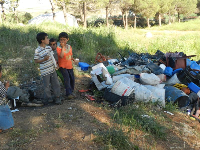 أطفال نازحون بمحاذاة بجانب تجمع نفايات (طارق أبو حمدان)