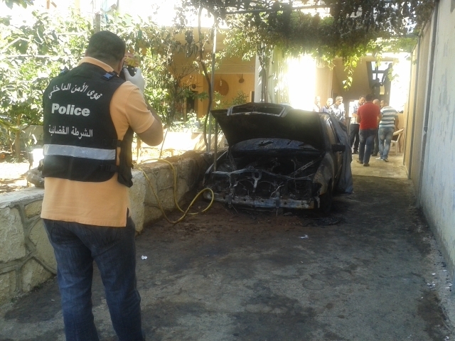 عنصر من الشرطة القضائية يعاين ويلتقط صور للسيرة المحترقة