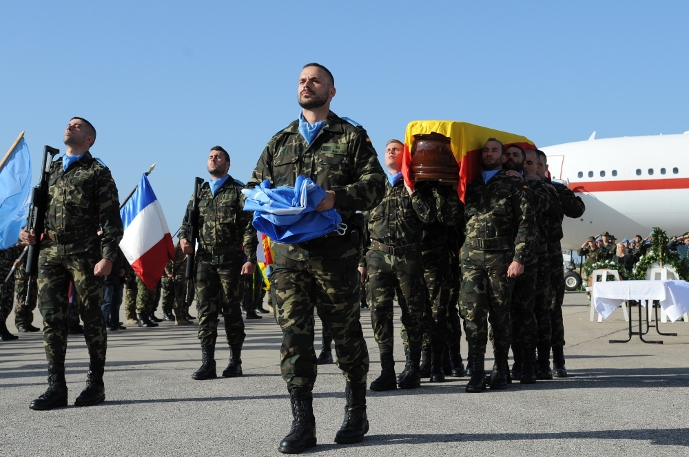 رفاق السلاح يحملون على الاكف رفيقهم الذي لف بالعلم الاسباني الى الطائرة7