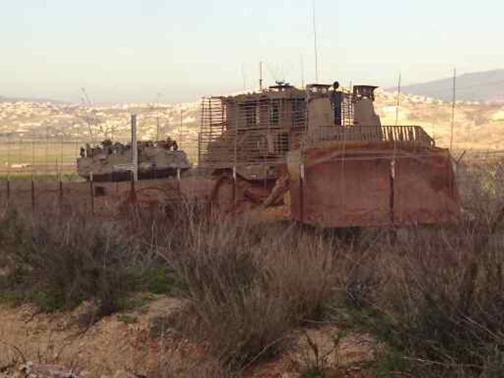 جرافة للعدو تسحب دبابة الميركافا المعطلة