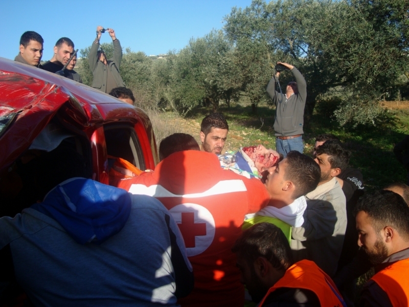 عناصر الصليب الاحمر والدفاع المدني يخرجون الجريح من السيارة
