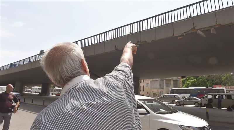 أحد الشهود على محاولة الانتحار، يشير إلى المكان الذي قفز منه أحمد في الكولا أمس (عباس سلمان)