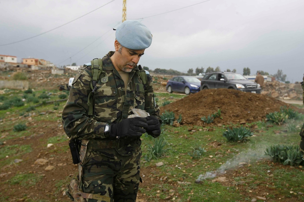 جندي دولي يعاين بقايا القذائف التي اطلقها العدو  على الوزاني