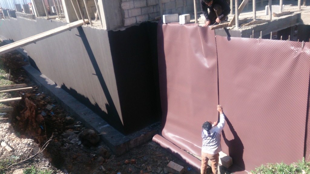 4- أعمال جدار الدعم وعزله (الطبقة السوداء هي مانع للنش والرطوبة فيما الطبقة ذات اللون الزهري هي لحماية مانع النش عند أعمال الردم خلف الجد