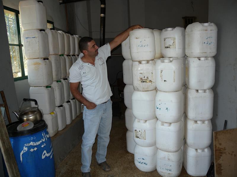 براميل زيت مكدسة تنتظر طريقاً للتصريف (طارق ابو حمدان)