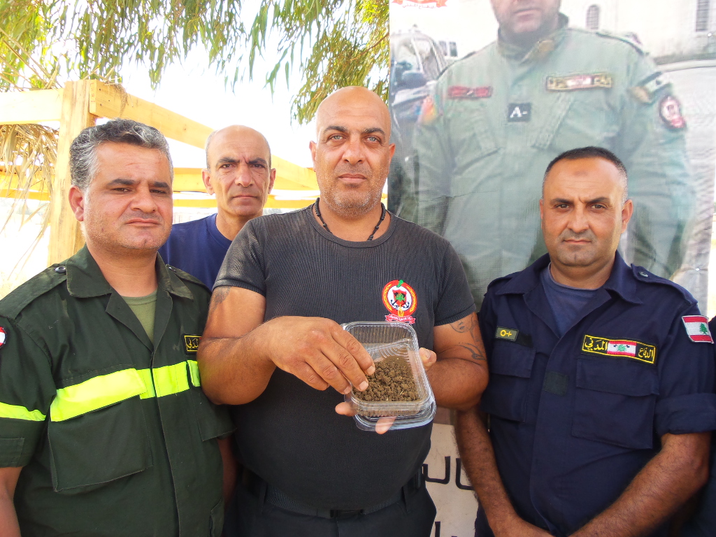 المتطوع جميل سري الدين يحمل حفة تراب ليضعها على ضريح رفيقهم