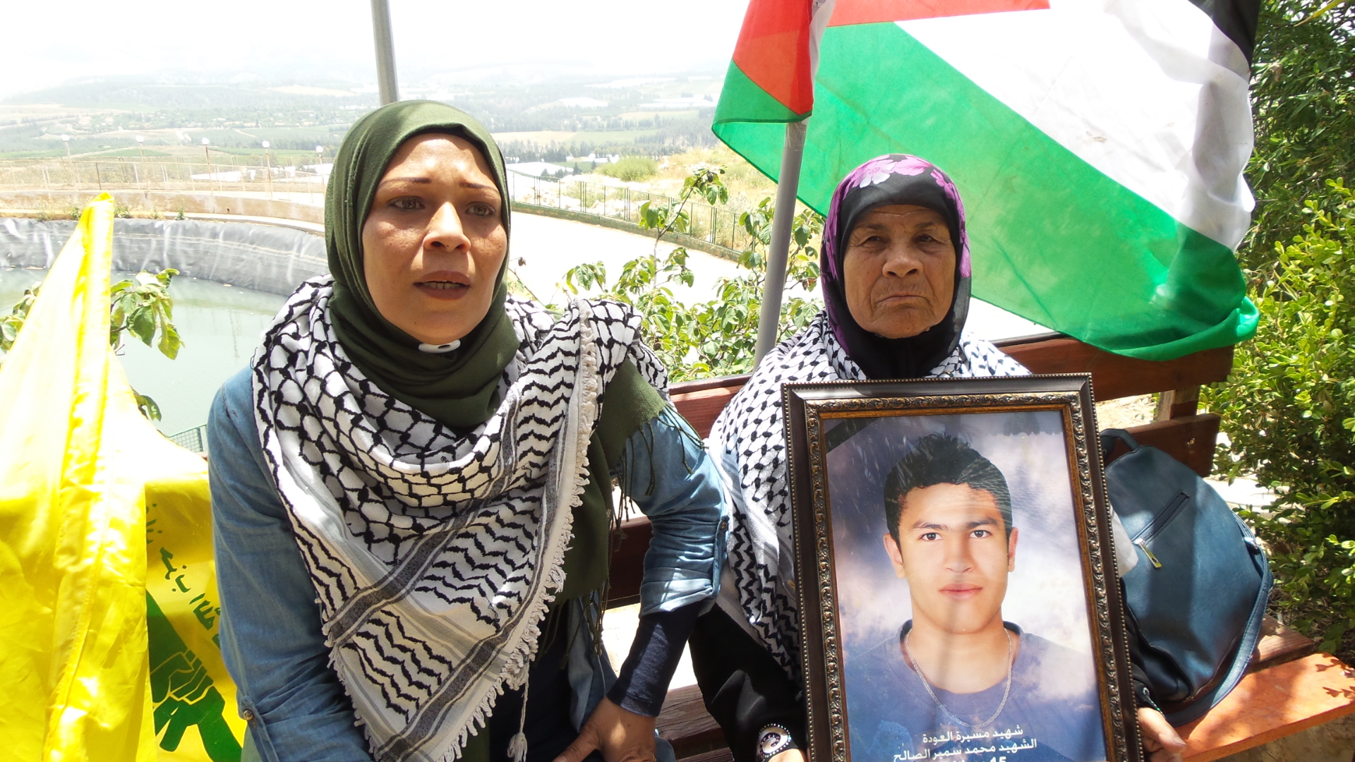 والدة شهيد العودة محمد سمير الصالح تحمل صورته