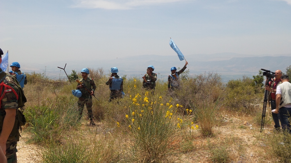 عناصر دولية ترفع علم الامم المتحدة عند خط الانسحاب