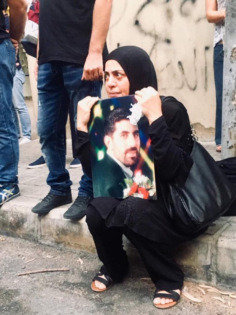 شقيقة الشهيد مهدي ابراهيم تحمل صورته