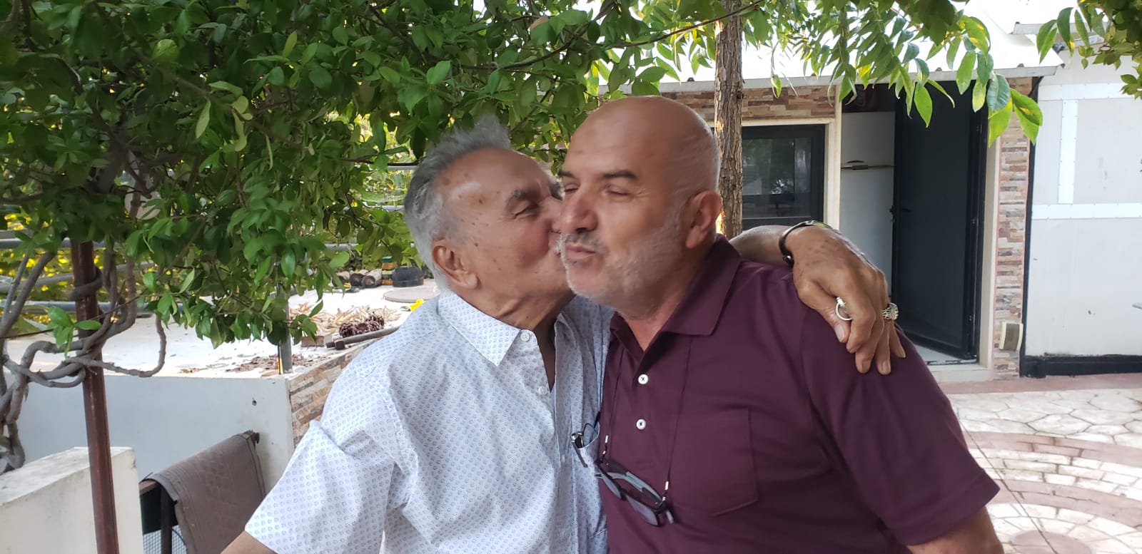 المختار حسين قنصور (أبو فيروز) وقبلة على خدّ الحاج رضا حسّان (شقيق المختار أحمد حسّان)