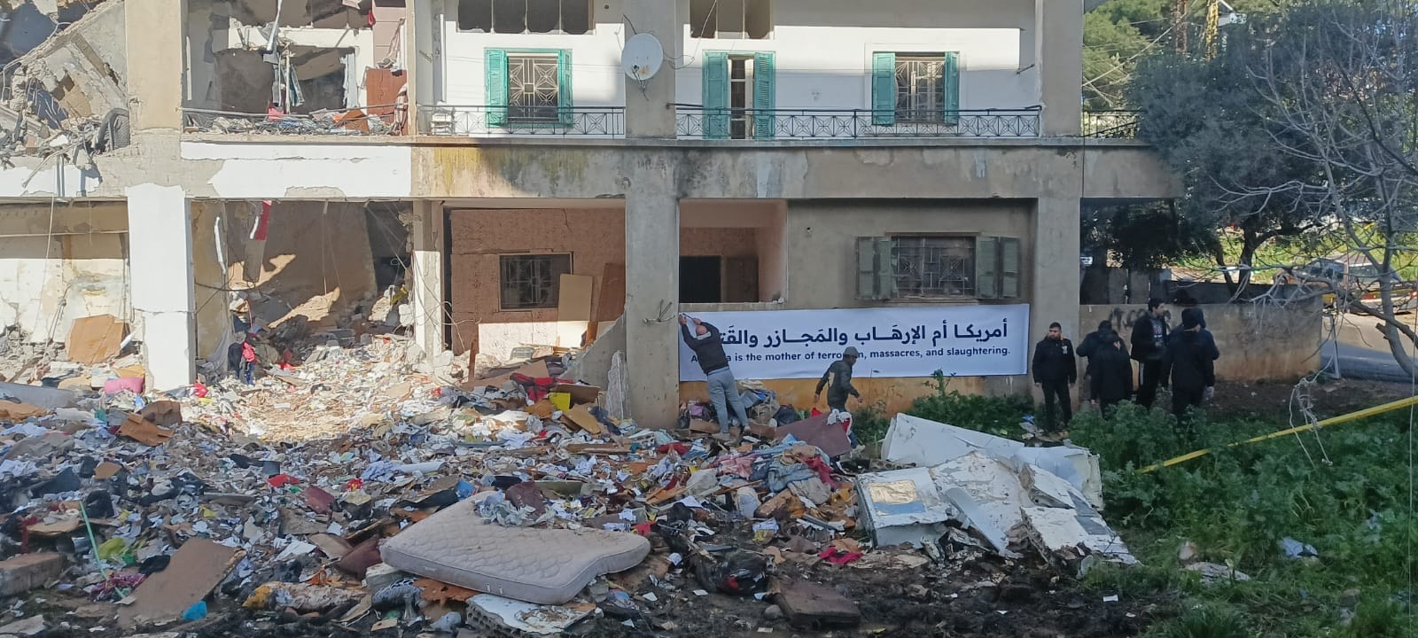 رفع سكان المبنى على مدخله لافتة كبيرة كتب عليها باللغتين العربية والانكليزية «امريكا ام الارهاب والمجازر والقتل»