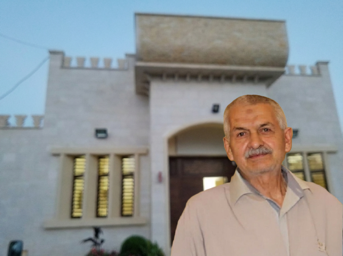 المرحوم يونس محمد القاعوري وفي الخلفية قاعة بلدية الخيام، التي تبرع ببنائها الحاج أكرم حمّود