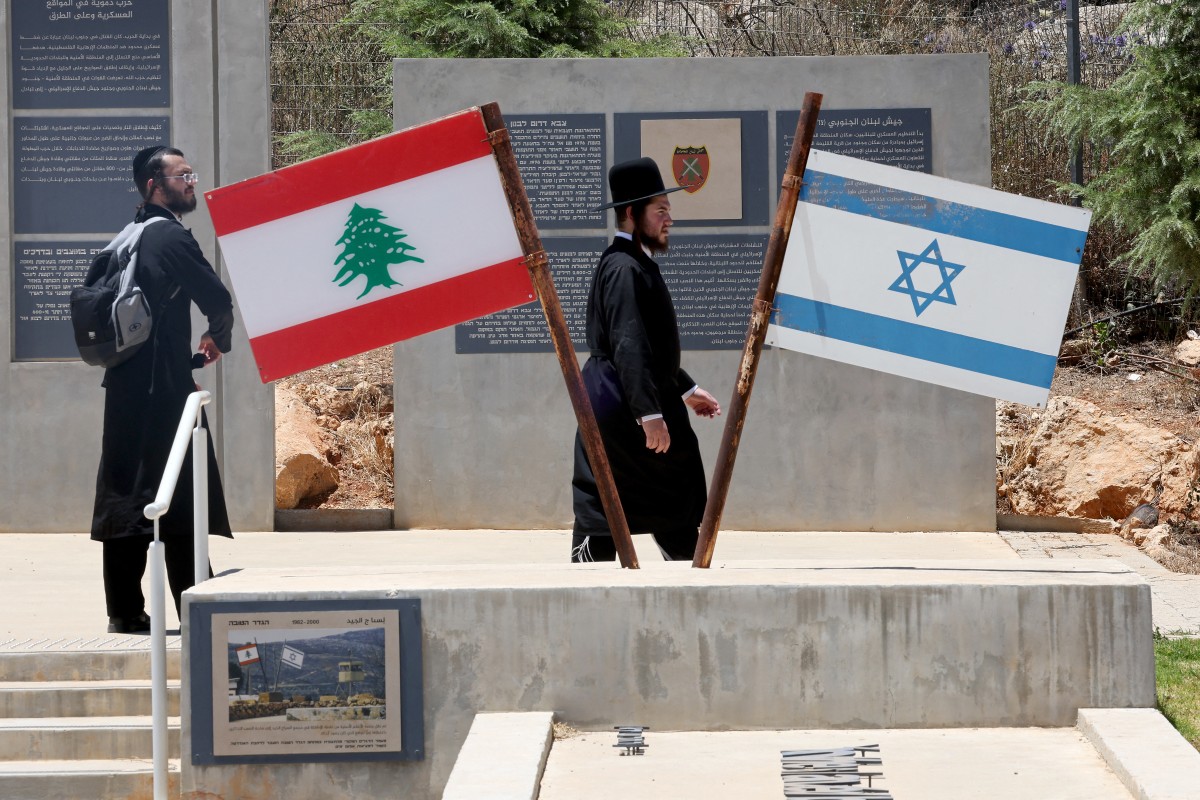 رفع العلمين الإسرائيلي واللبناني في موقع تذكاري على الحدود مع لبنان، شمال إسرائيل​​​​​​​ (ا ف ب)