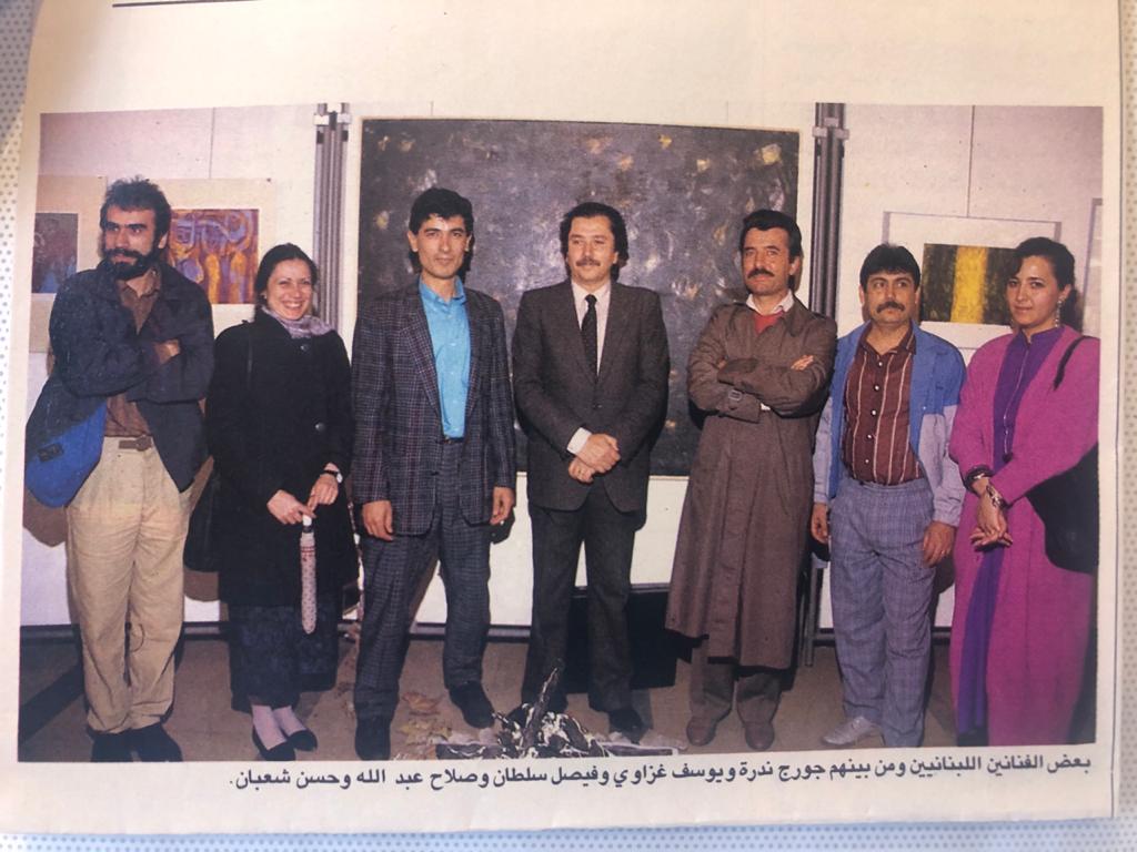 صورة تجمع مجموعة من الفنانين في أحد معارض الدكتور يوسف غزّاوي في باريس. (الفنان التشكيلي والناقد د. فيصل سلطان متوسطاً صلاح عبدالله ود. غزّاوي)